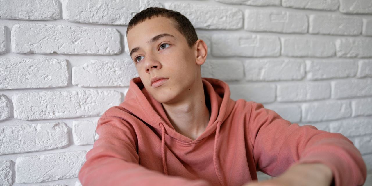 A close-up of a sad teenager sitting on the floor | Source: Magnific