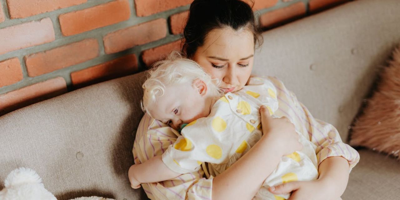 A woman gently holding a toddler in her arms | Source: Pexels