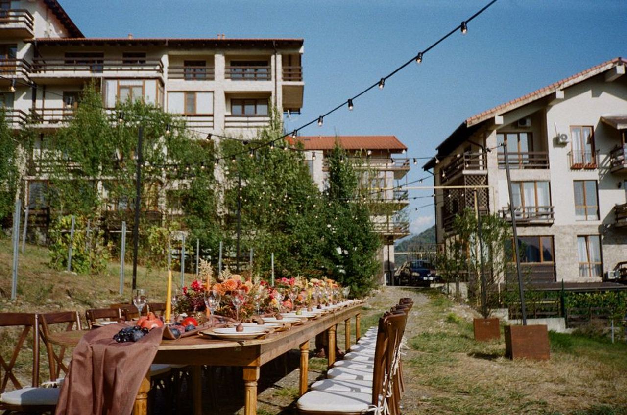 Charming outdoor dining setup with flowers and string lights in Krasnaya Polyana, Russia.