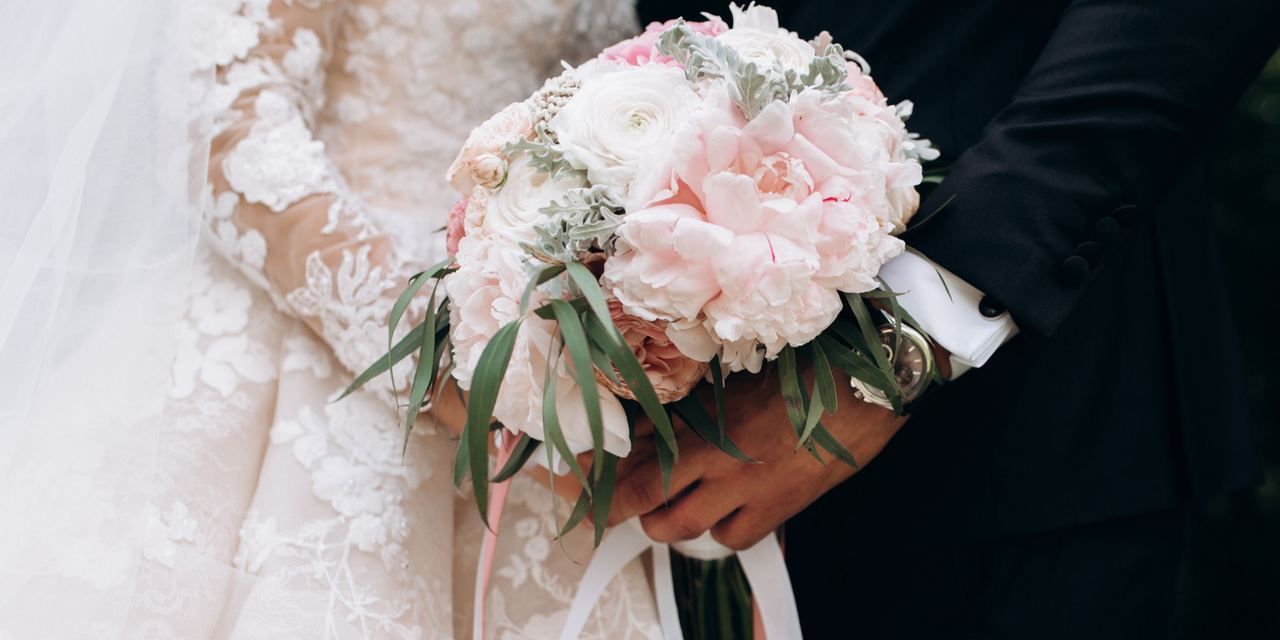 A bridal couple holding a bouquet | Source: Magnific