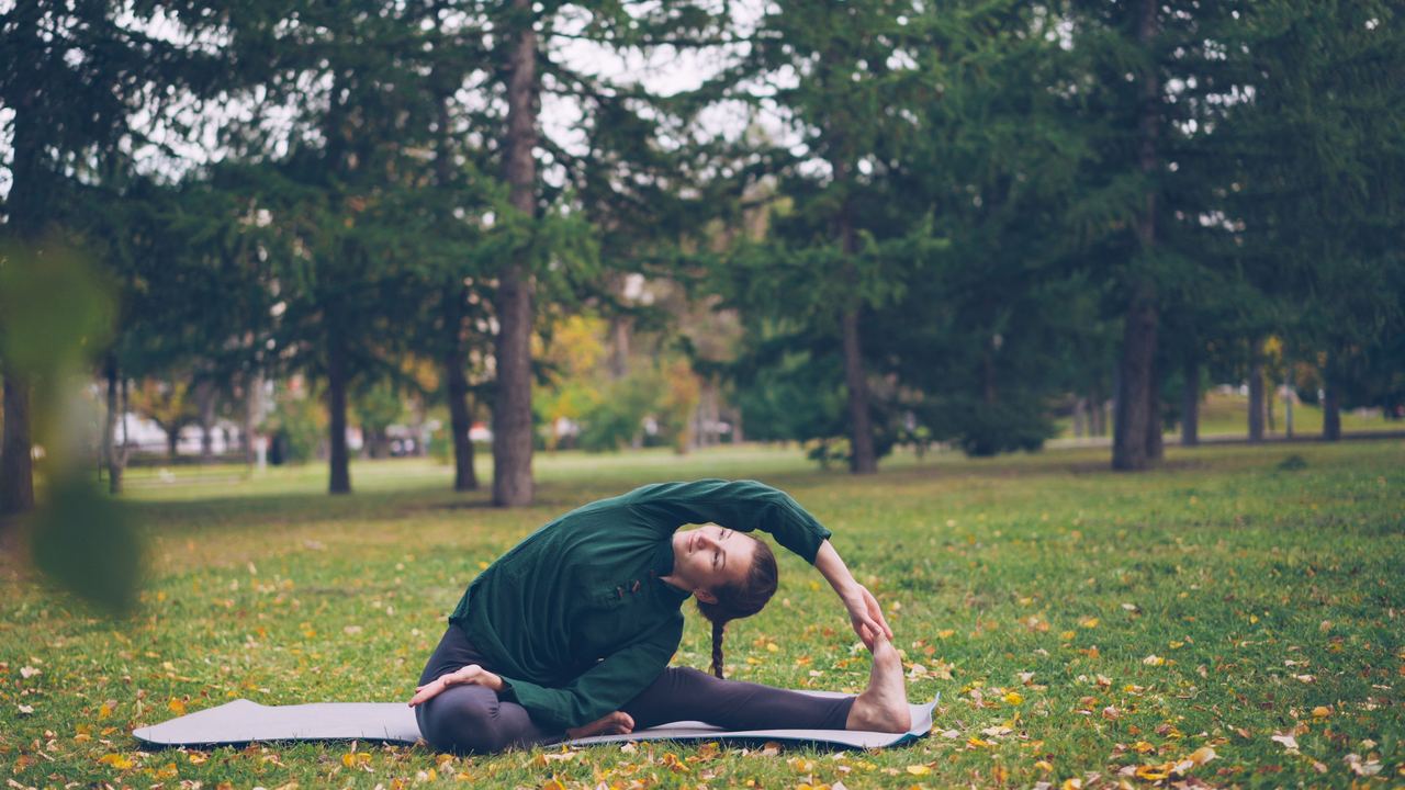 Woman performing yoga stretches on a mat | Source: Pexels