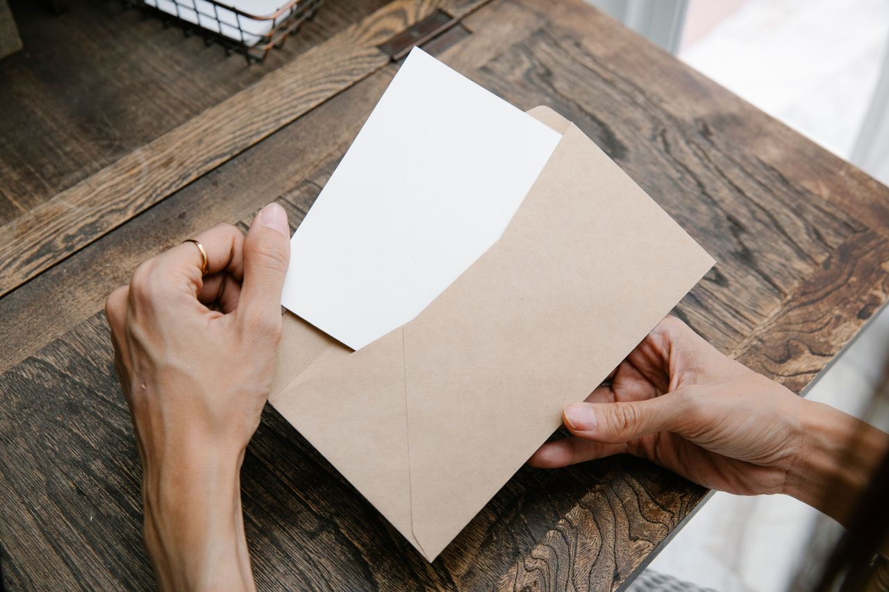 A woman holding an envelope | Source: Pexels