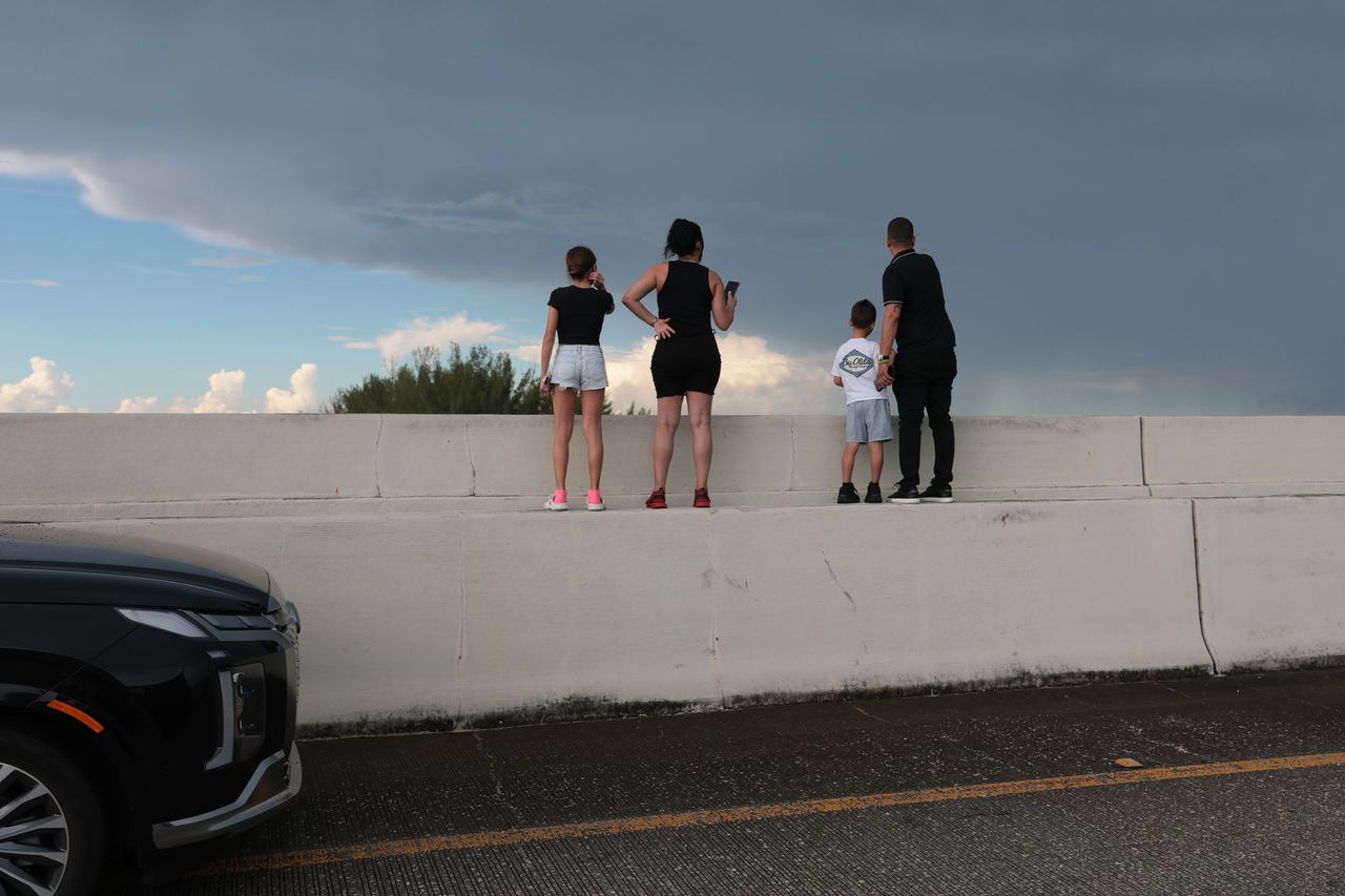 eople stopped along a roadway to look toward the crash scene as the emergency unfolded near Miami International Airport. The incident disrupted airport operations, with runways and taxiways temporarily closed and a full ground stop put into effect. | Source: Getty Images