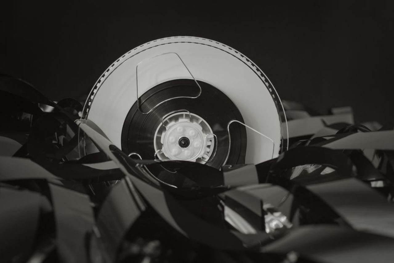 Close-up of a vintage cassette tape against a black background, showcasing retro technology.