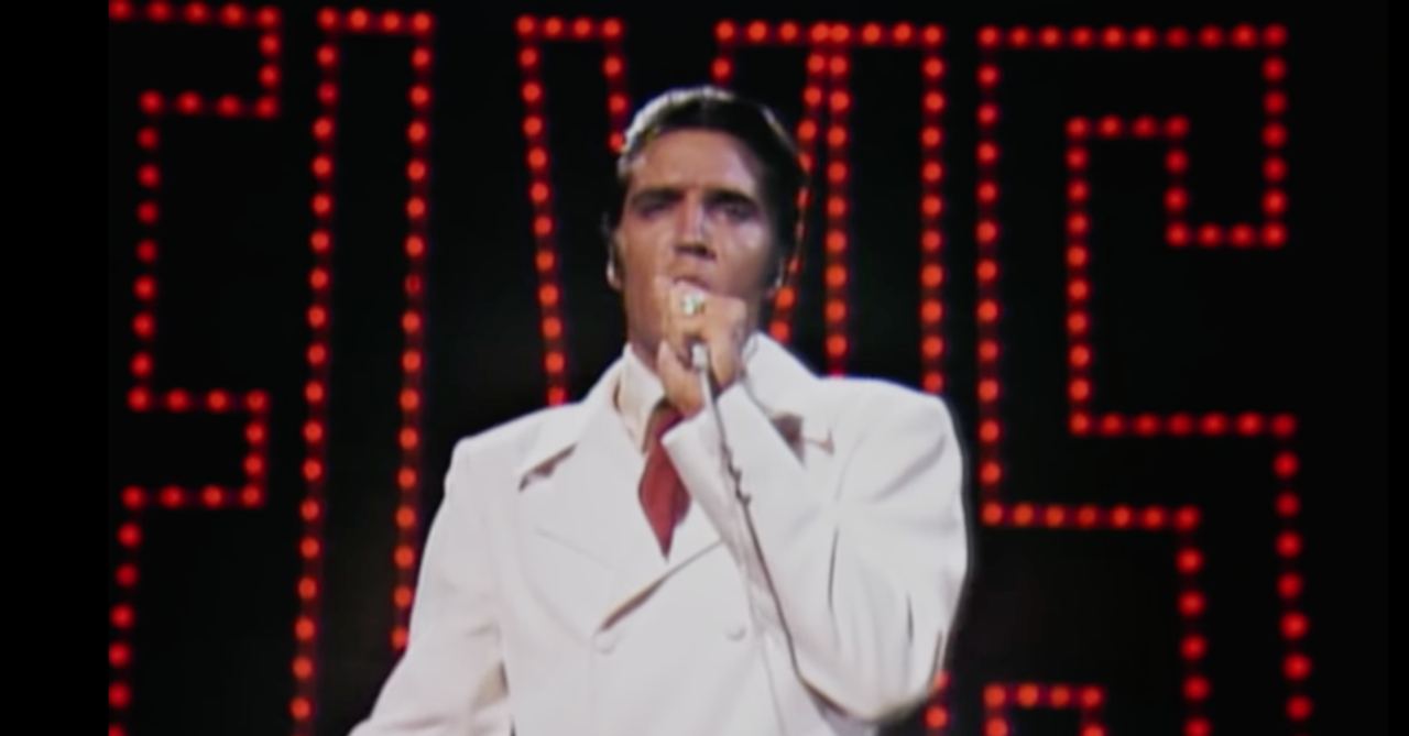 Elvis Presley performing in his white suit during the 1968 television special. Television still reproduced by Crosswalk.