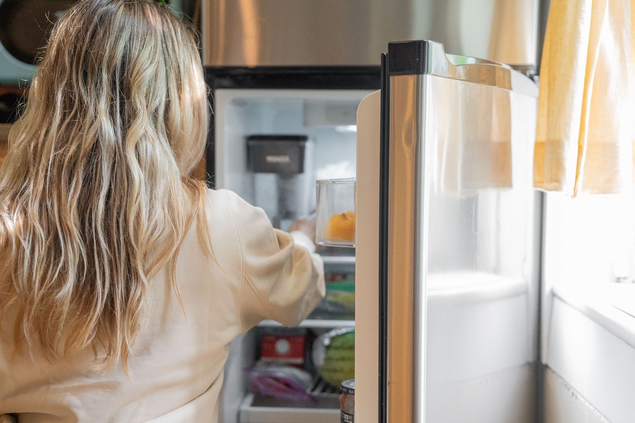 A woman getting food from a refrigerator | Source: Pexels