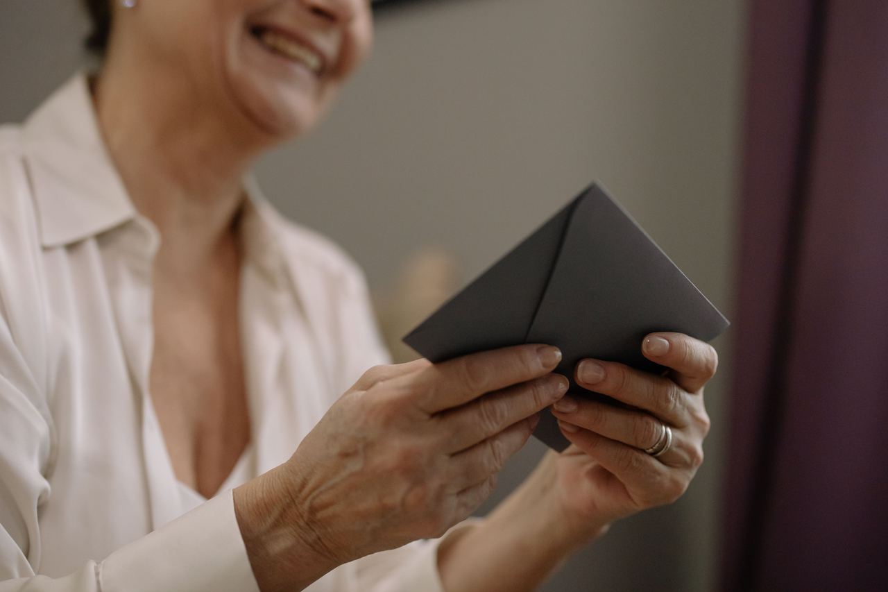 A close-up of a woman holding an envelope | Source: Pexels