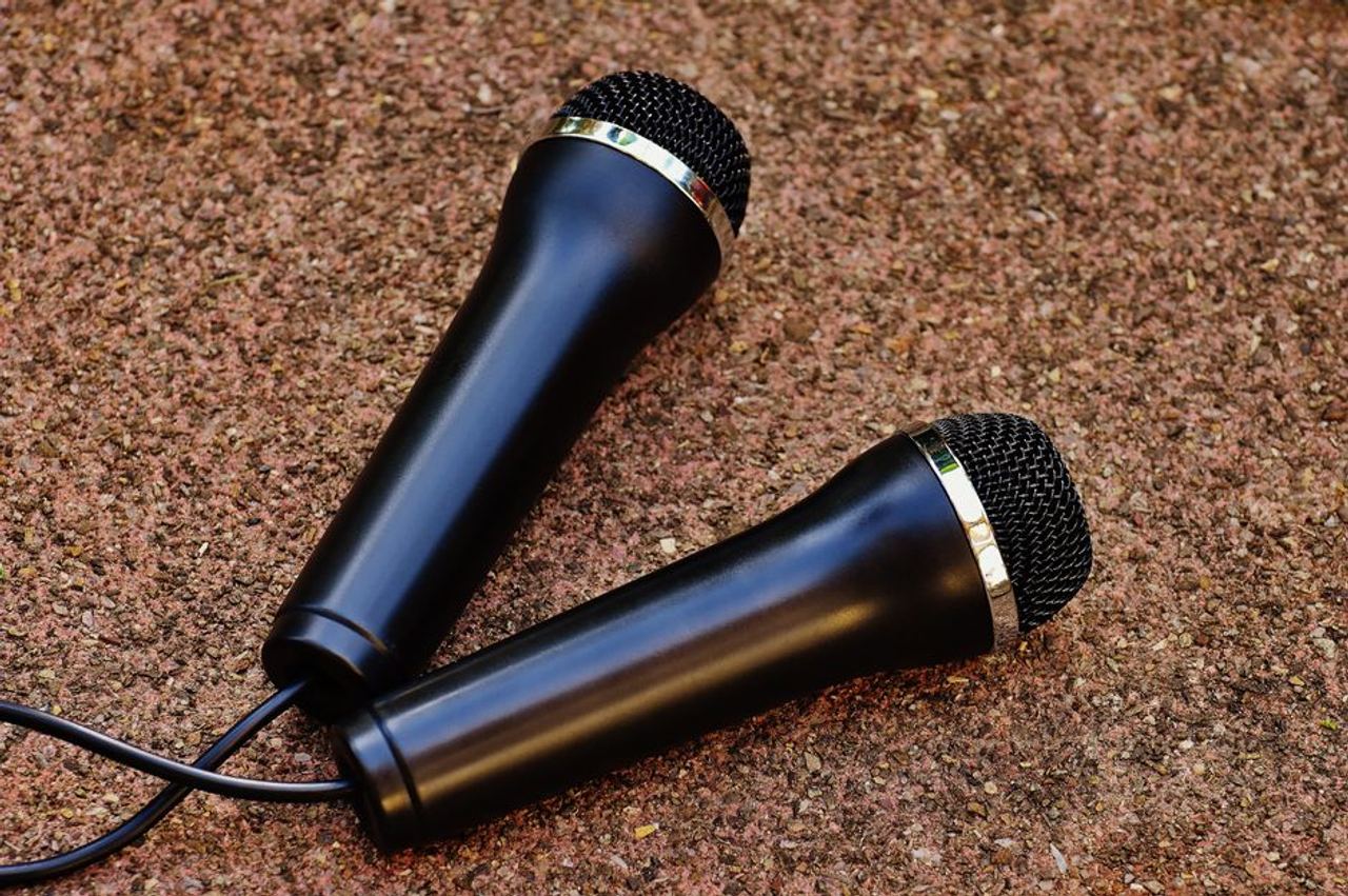 Close-up of two black handheld microphones on a textured background, perfect for audio themes.