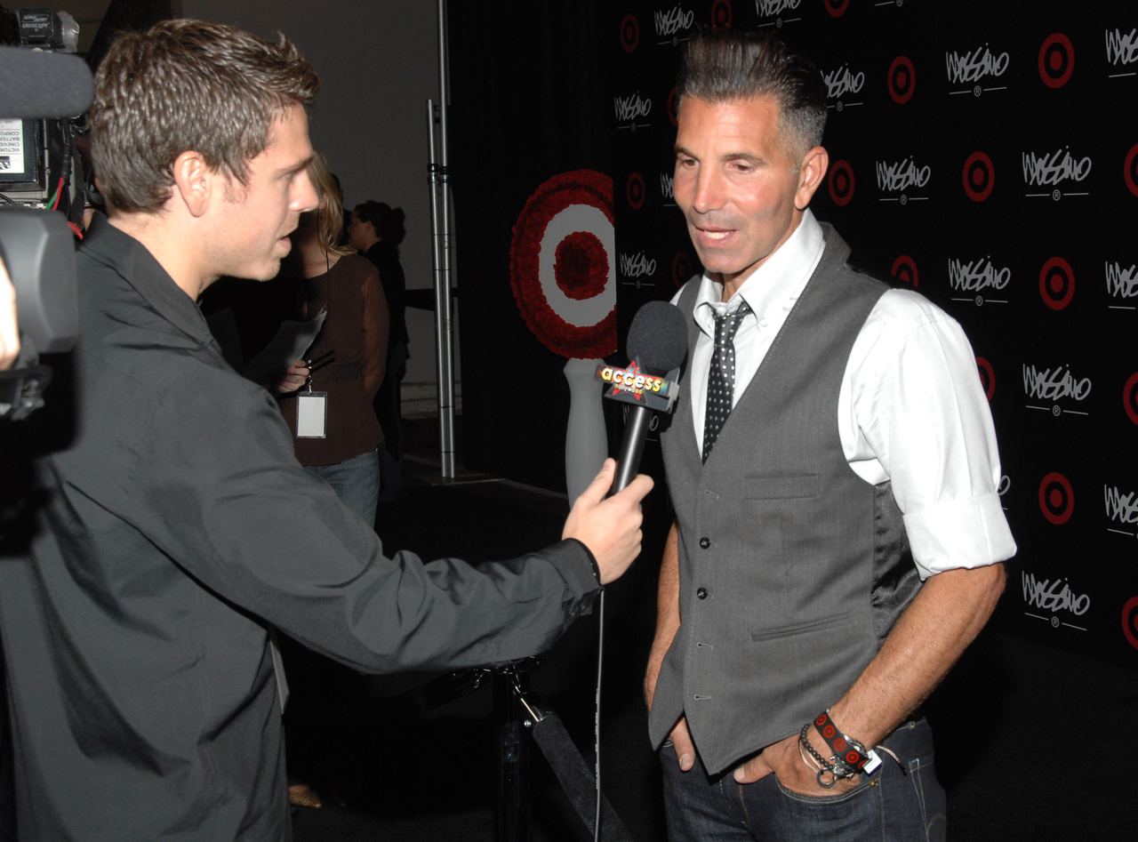 Mossimo Giannulli speaks with a reporter at a Los Angeles Fashion Week party for his namesake brand. His fashion career gave the couple a second source of high-profile success outside Loughlin's work in Hollywood. | Source: Getty Images