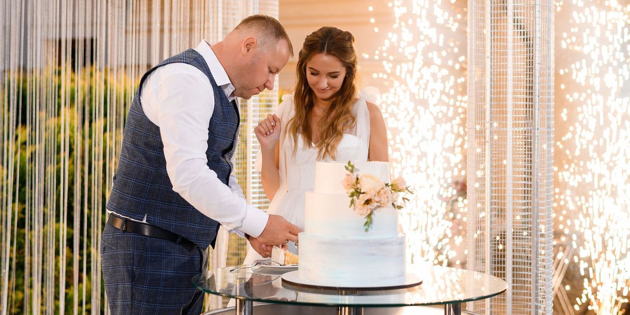 A bridal couple cutting their wedding cake | Source: Magnific