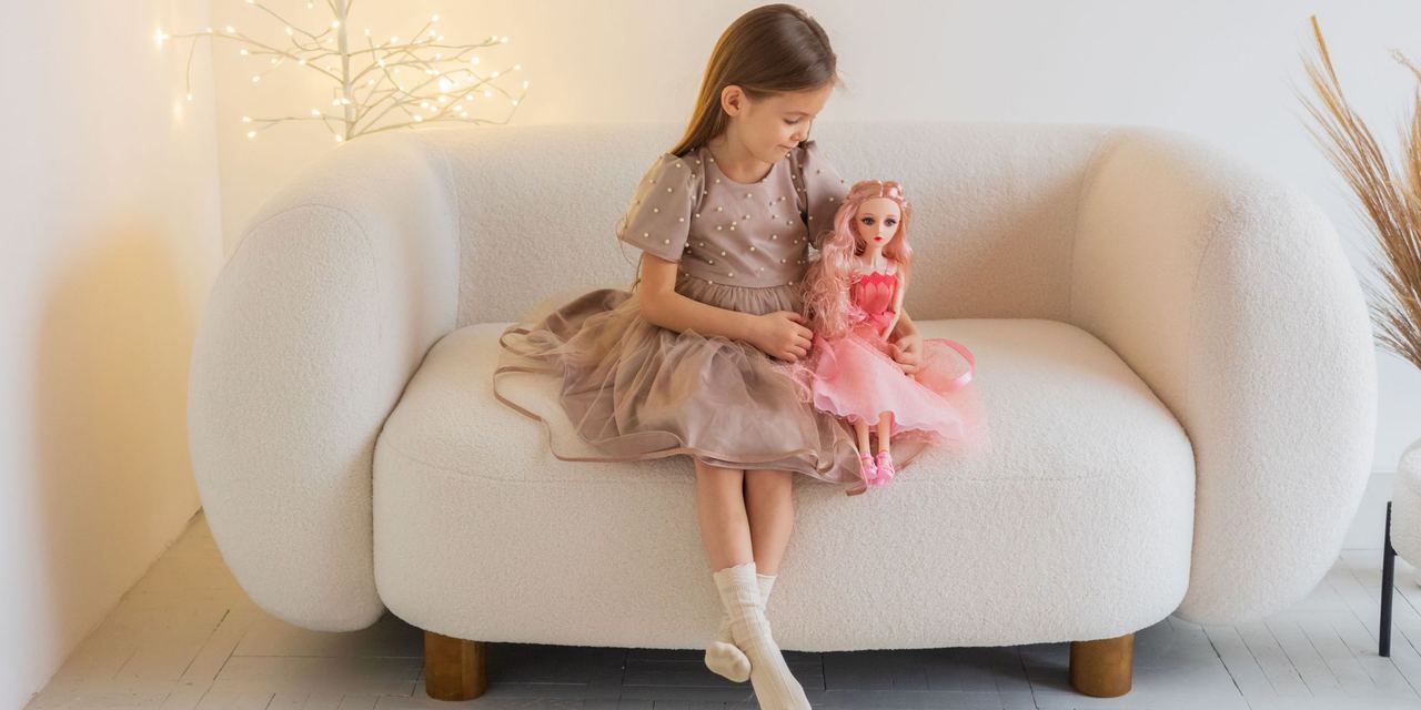 A little girl holding a doll | Source: Pexels