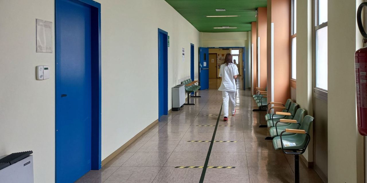 Hospital corridor with a healthcare worker walking away | Source: Pexels