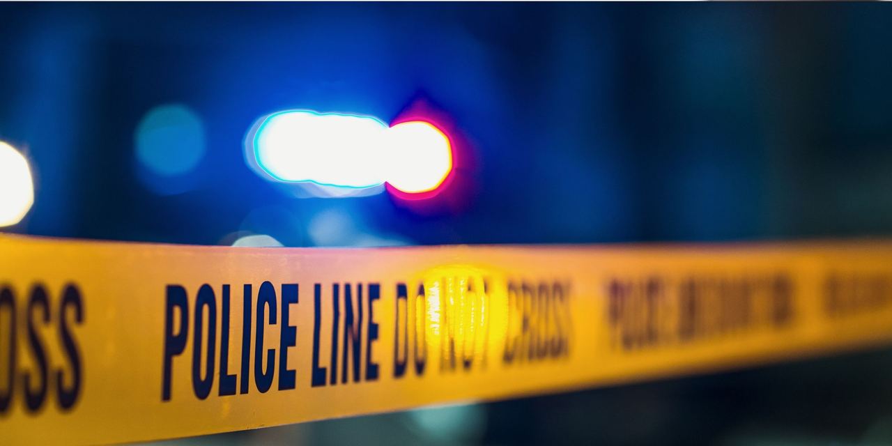 Close-up shot focused on yellow tape showing text "Police line do not cross" | Source: Shutterstock