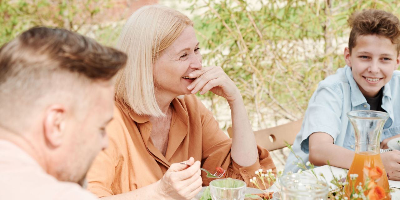 A happy matriarch enjoying a meal with her family | Source: Pexels
