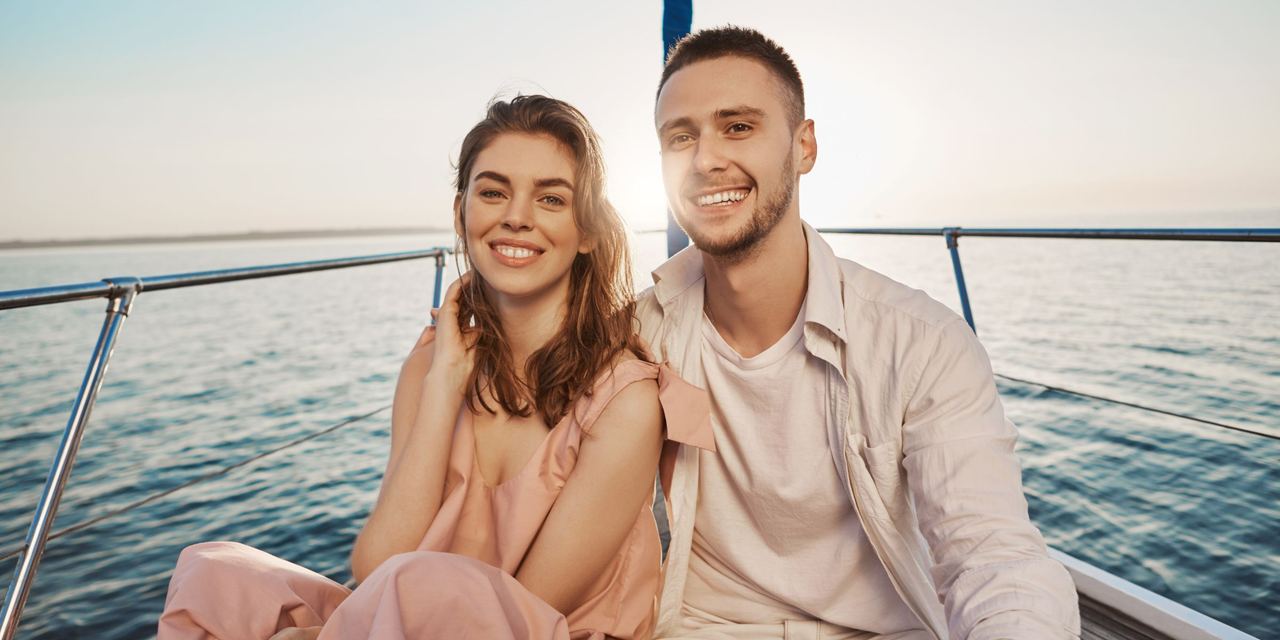 A smiling couple sitting on a boat | Source: Magnific