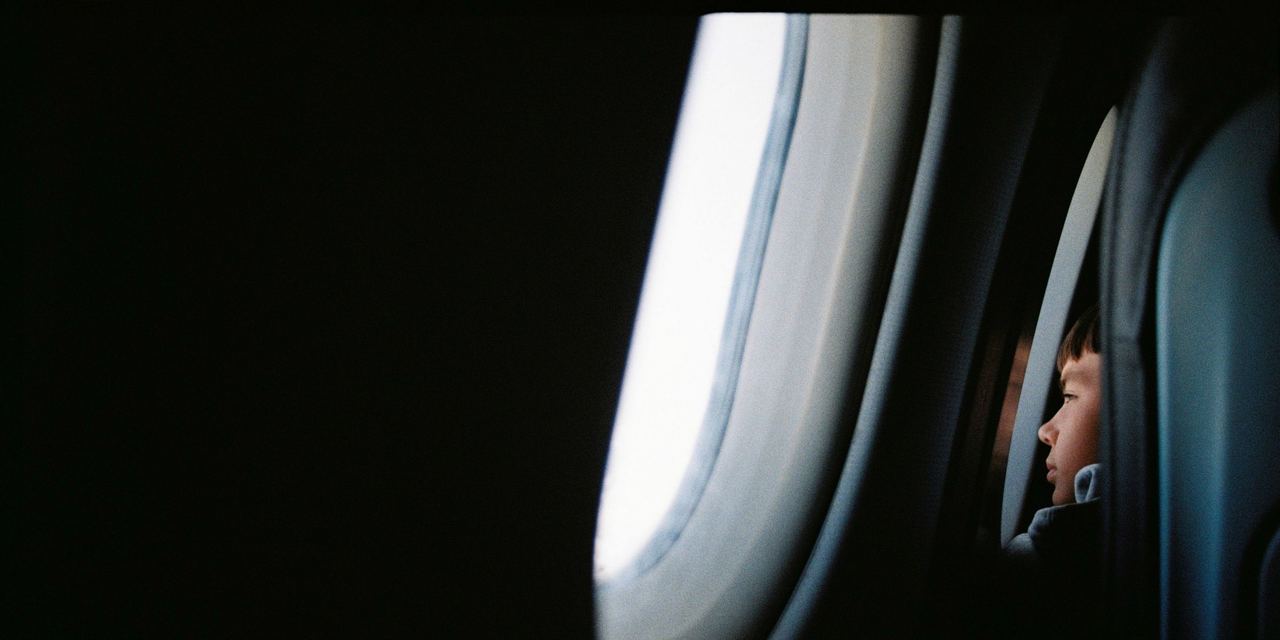 A boy looking out the airplane window | Source: Pexels