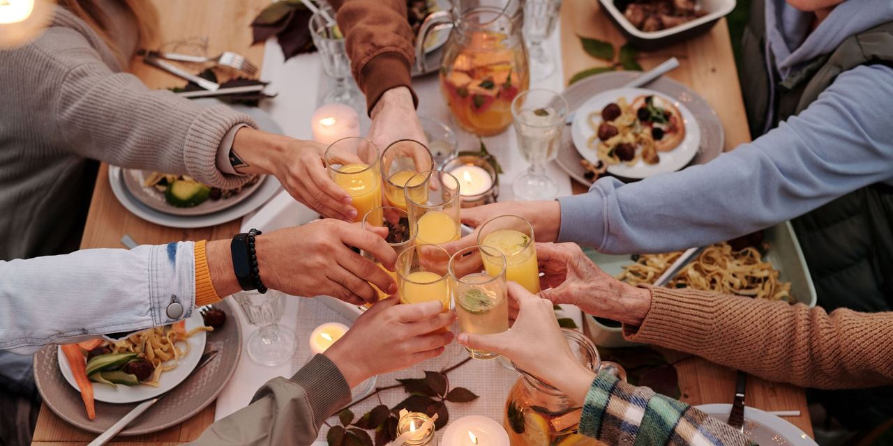 A group of people clinking glasses during a toast at a dinner party | Source: Pexels