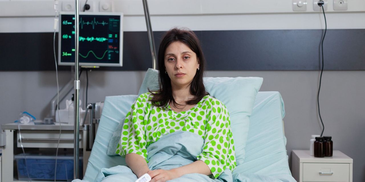 A woman sitting in a hospital bed | Source: Magnific
