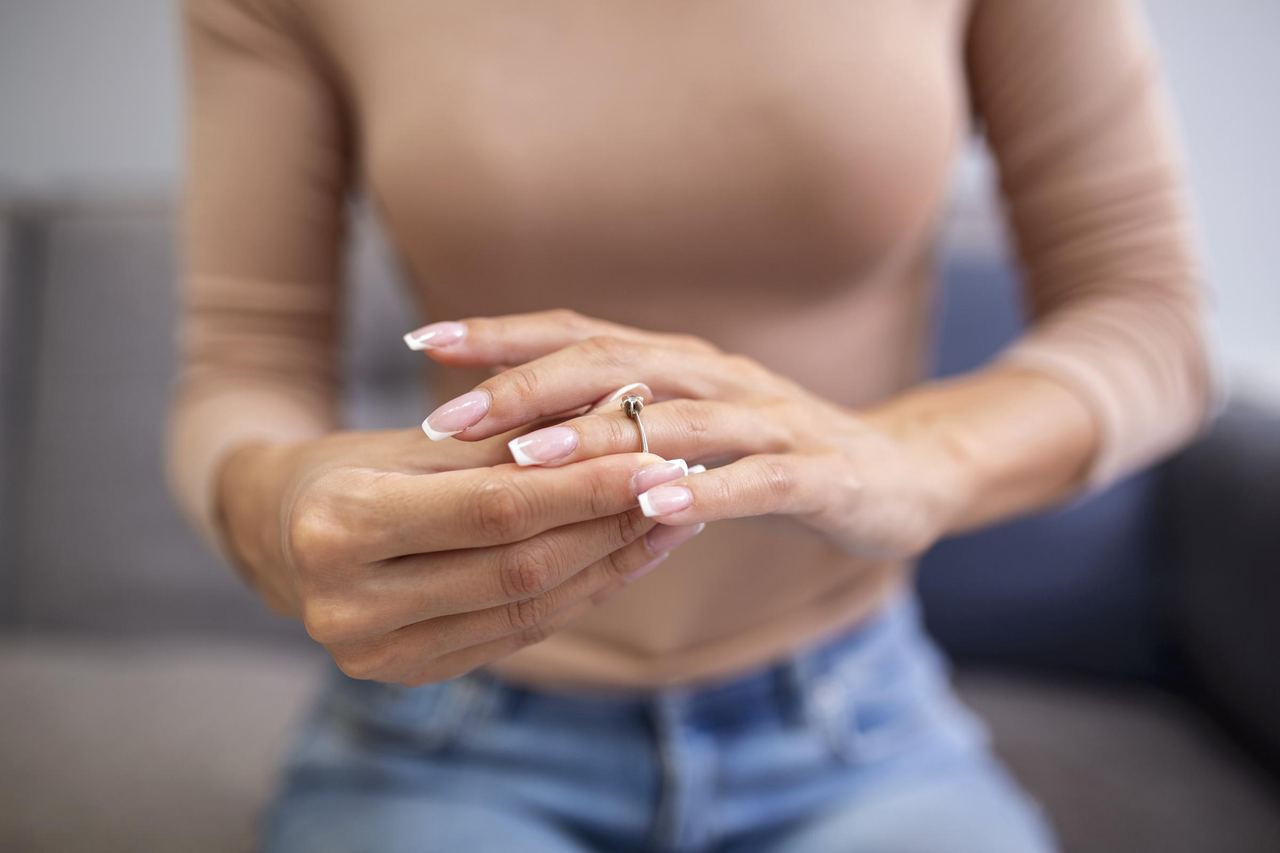 Close up young woman taking off wedding ring | Source: Magnific