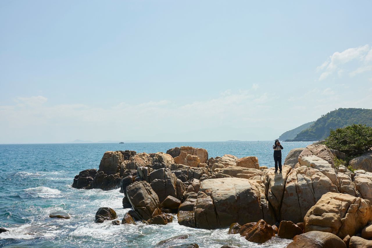 A person on rocks next to the ocean | Source: Pexels