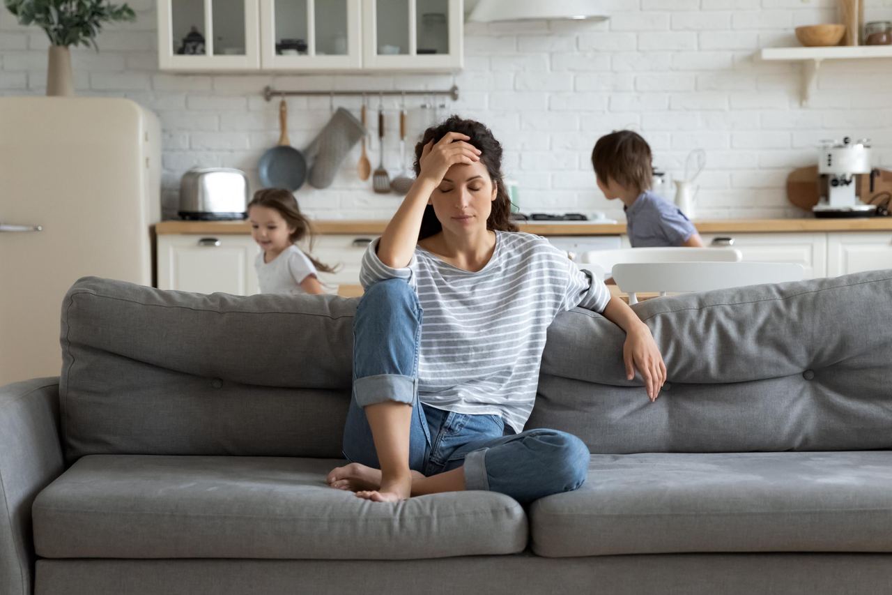 A mother sitting on a couch | Source: Shutterstock