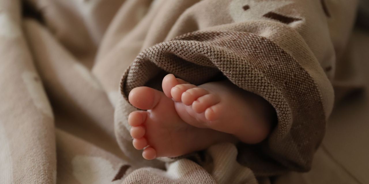 Baby feet wrapped in a blanket | Source: Pexels