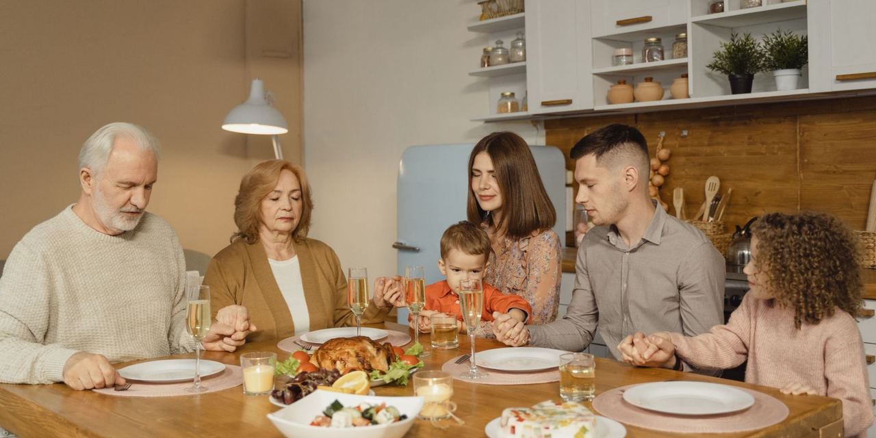A family gathers for heartfelt prayer before enjoying a festive dinner | Source: Pexels