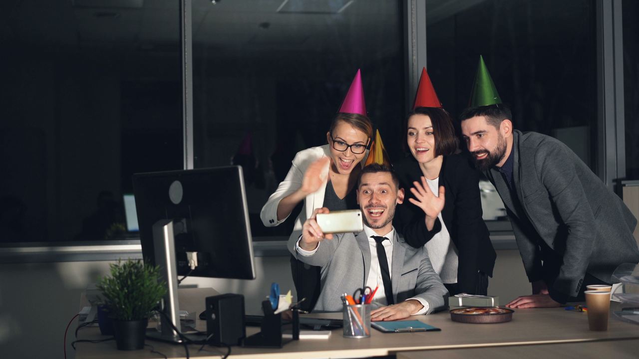 Coworkers celebrate in the office with party hats | Source: Pexels