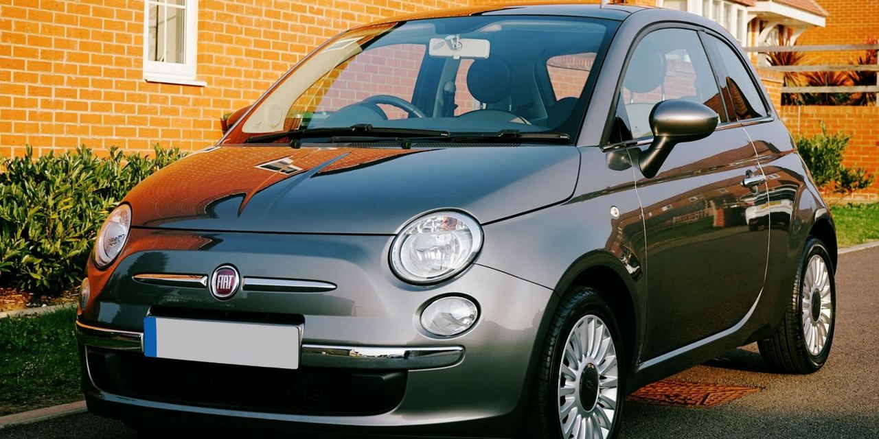 Gray compact Fiat parked outside a brick home | Source: Pexels