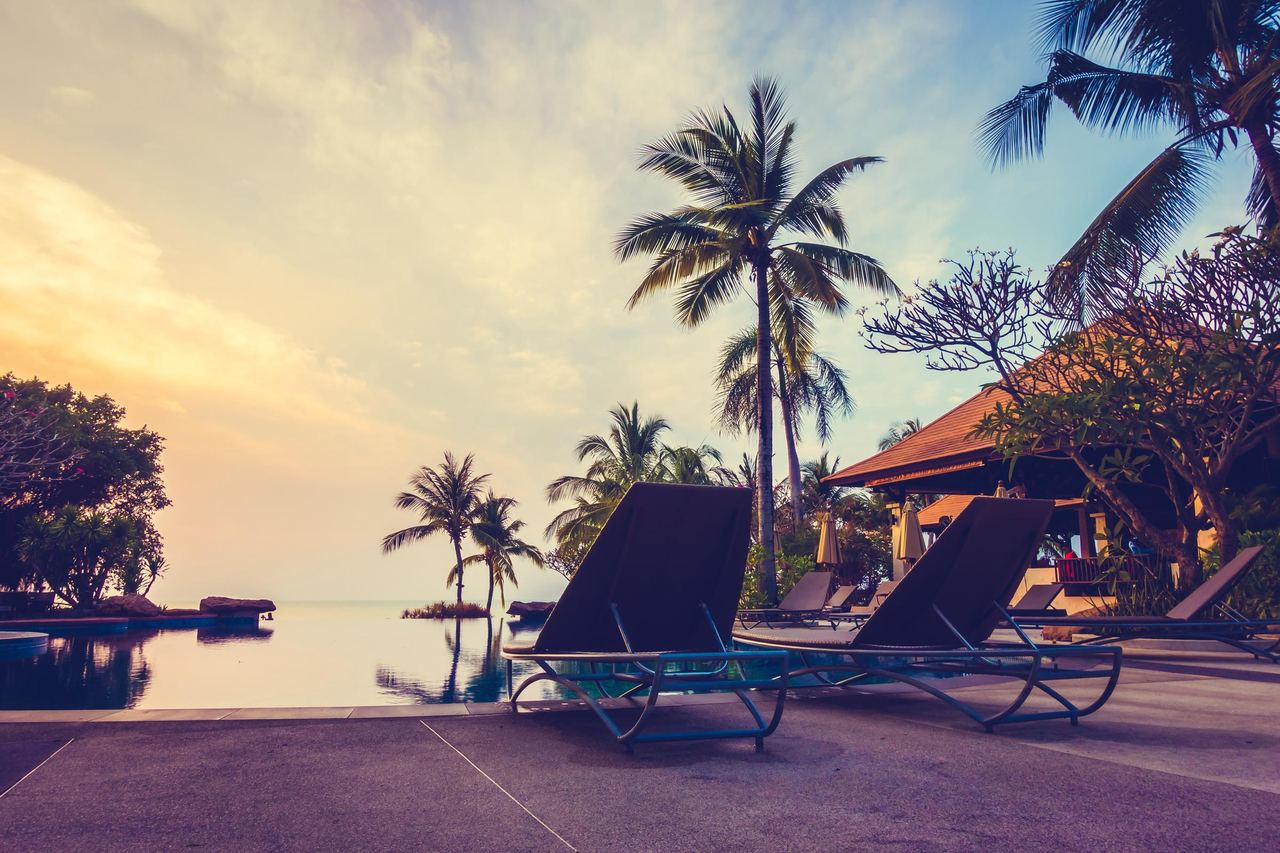 Two pool chairs looking at a sunset | Source: Magnific