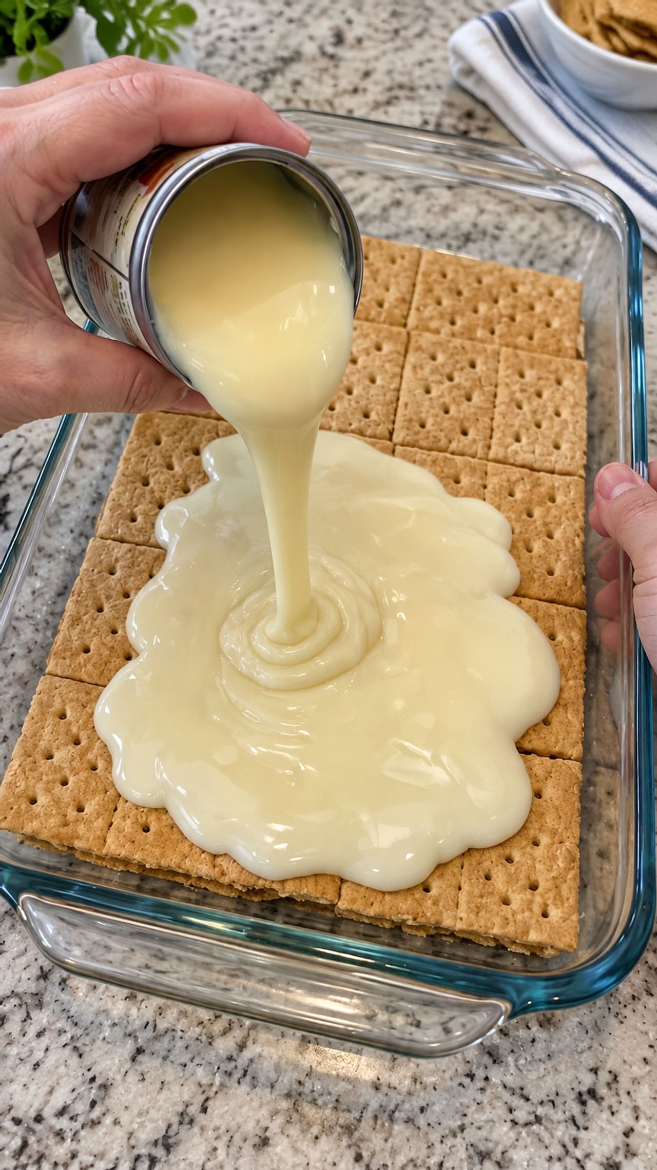 Pour sweetened condensed milk over whole, unbroken graham cracker sheets in the clear glas