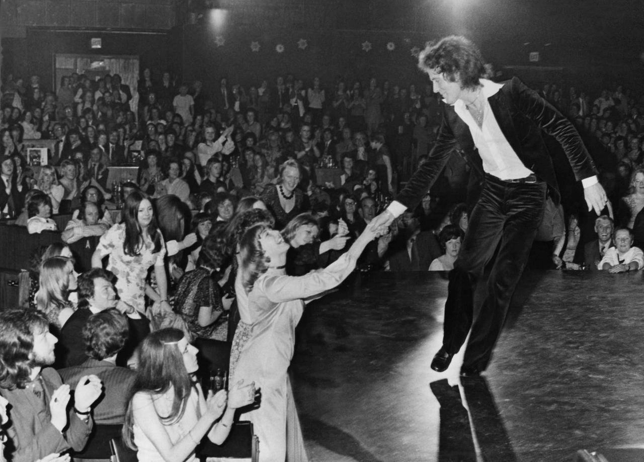 Gilbert O'Sullivan onstage in 1974, connecting directly with the audience.