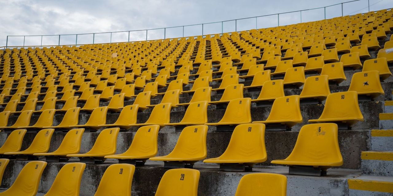 Rows of empty yellow stadium seats | Source: Pexels