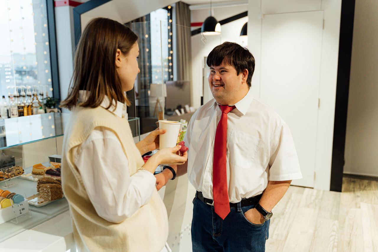 A man with Down syndrome is talking to a woman in a café | Source: Pexels