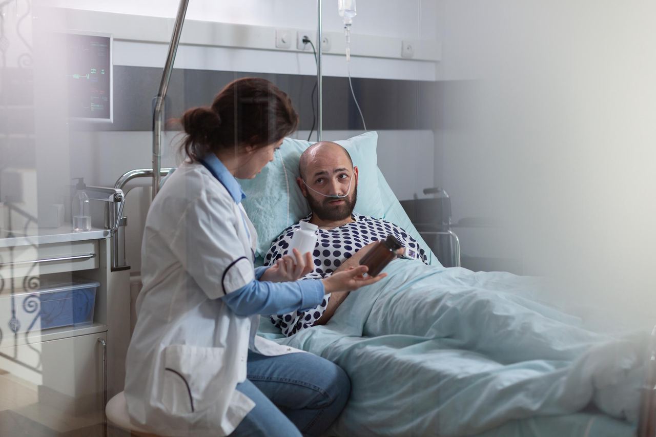 Sick man with a nasal oxygen tube resting in bed during a medical examination | Source: Magnific