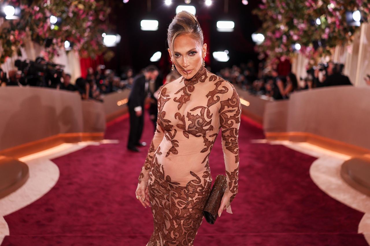 Jennifer Lopez poses on the red carpet in a high-neck sheer embroidered gown at the 2026 Golden Globes | Source: Getty Images