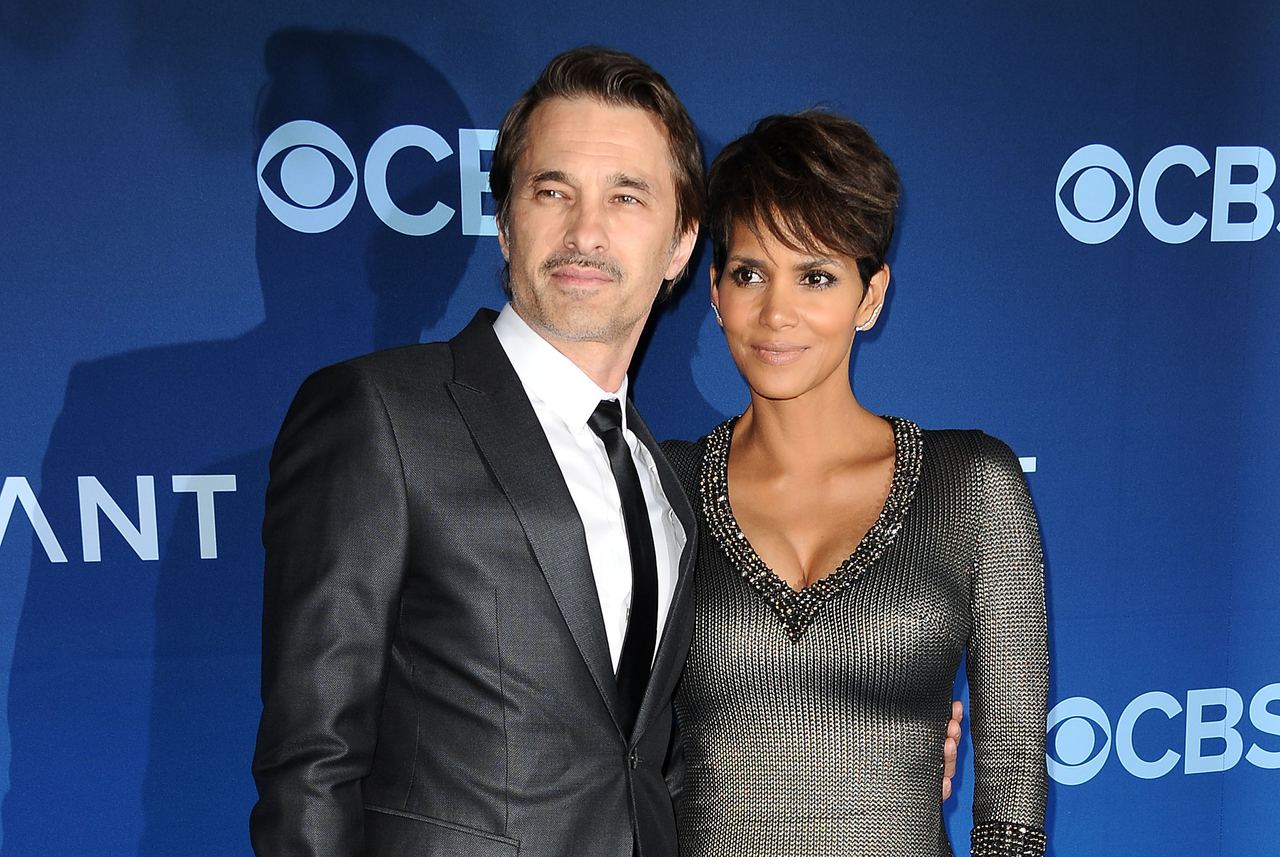Actor Olivier Martinez and actress Halle Berry posed together on the red carpet at the premiere of "Extant" held at the California Science Center on June 16, 2014, in Los Angeles, California. Martinez looked sharp in a dark charcoal tailored suit, crisp white dress shirt, and slim black tie, while Berry complemented him in a metallic textured gunmetal knit dress featuring a sparkling beaded neckline and her signature cropped pixie cut. | Source: Getty Images
