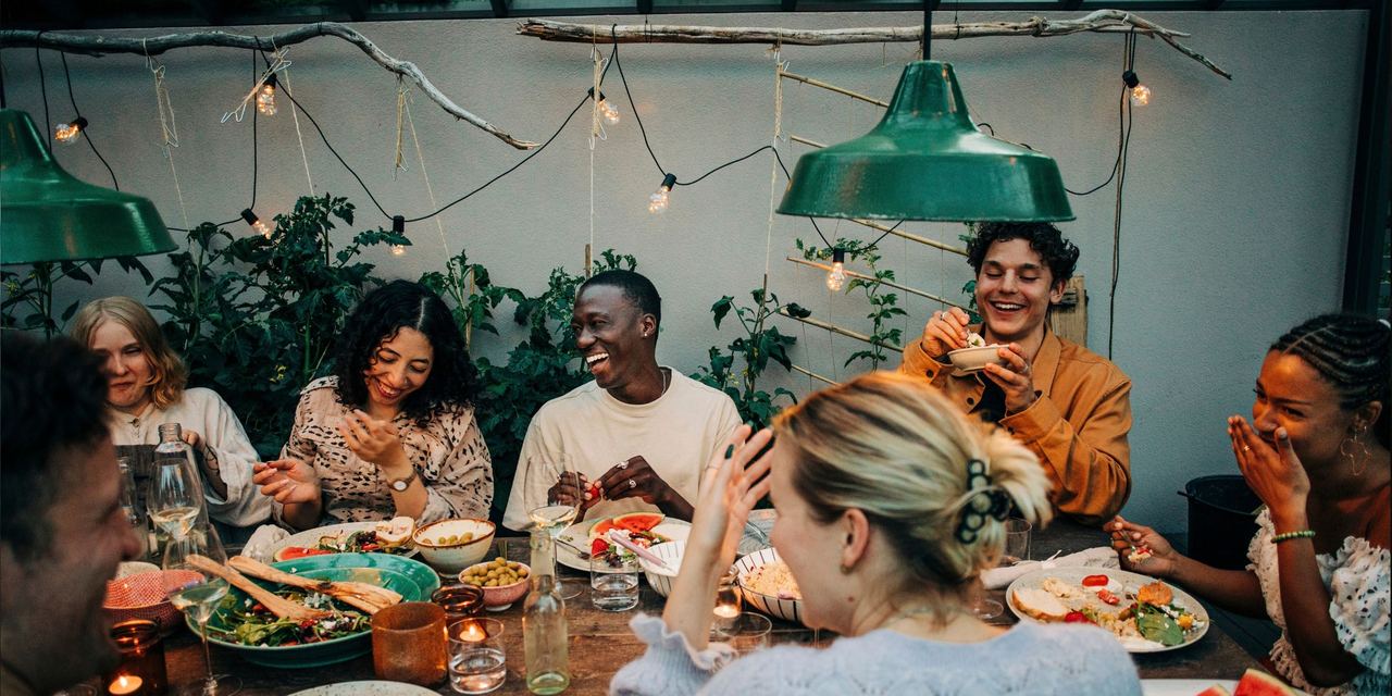 Cheerful business colleagues having dinner together in a garden | Source: Getty Images