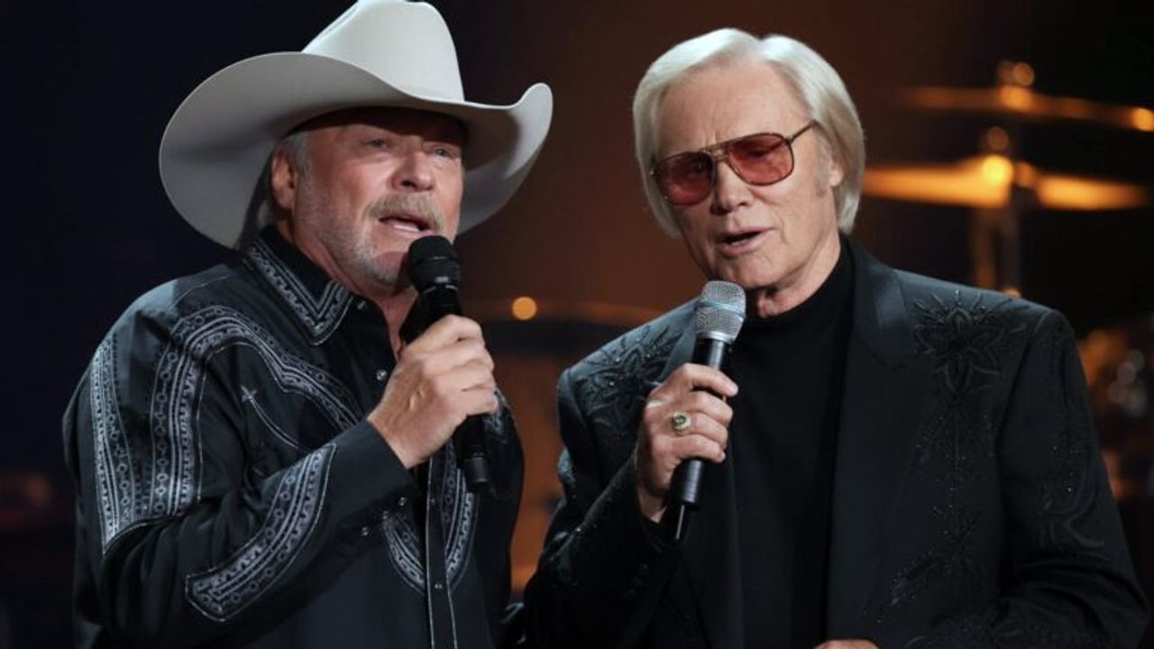 Alan Jackson and George Jones performing together on stage, their voices blending in a powerful Opry duet.