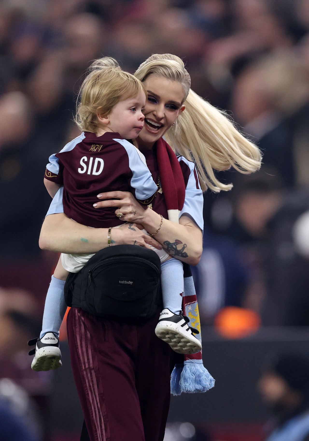 Kelly Osbourne held her son Sidney at an Aston Villa football match, where the little boy wore a personalized jersey featuring "SID" on the back and 1874, the year the club was founded. | Source: Getty Images
