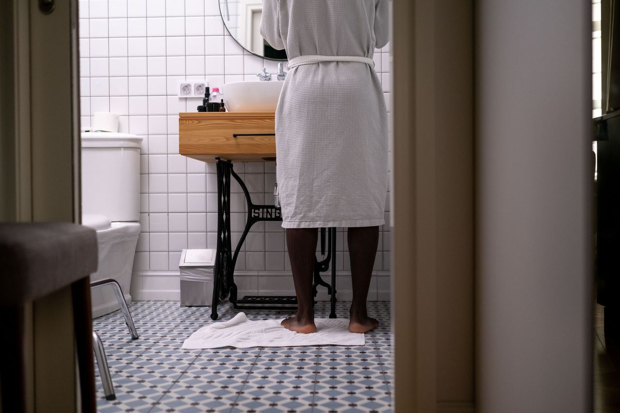 A person in a white robe in the bathroom | Source: Pexels