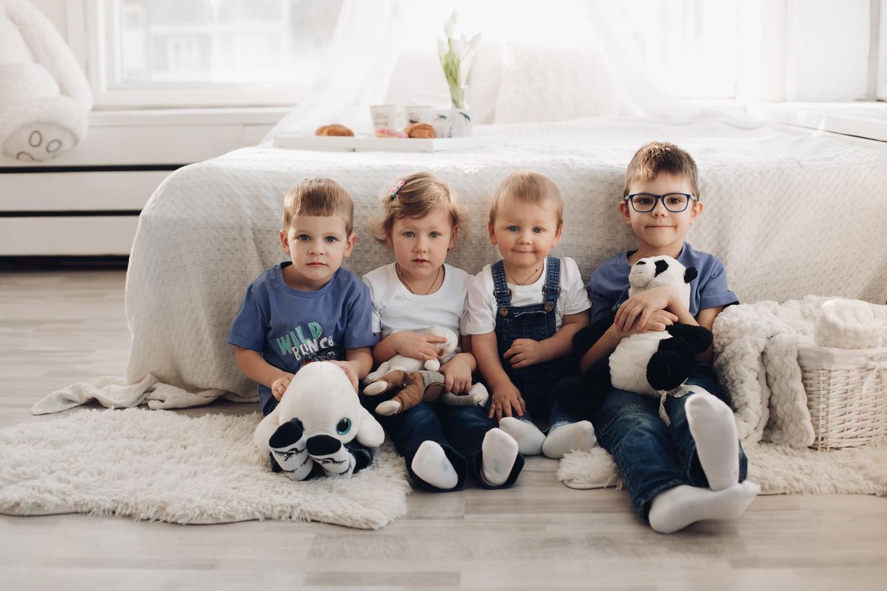 Four siblings sitting in a row | Source: Magnific