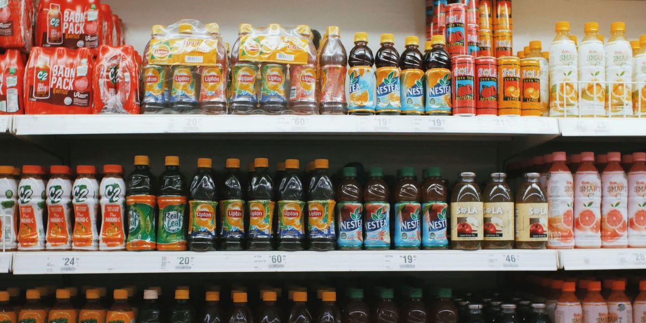 Bright rows of assorted drinks on a supermarket shelf | Source: Pexels