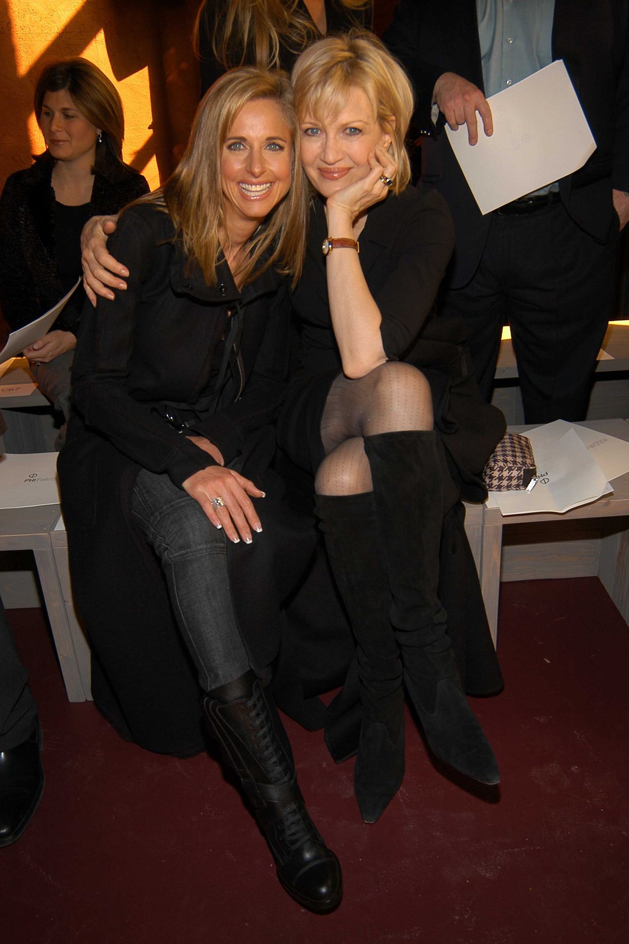 Susan Dell and Diane Sawyer sat close together and smiled warmly from the front row of the Phi Fall 2004 Fashion show in New York on February 13, 2004. Both opted for chic, monochromatic black ensembles, with Susan wearing a tailored dark coat over trousers paired with lace-up leather boots, while Diane posed beside her in a black dress, sheer hosiery, and knee-high suede boots. | Source: Getty Images