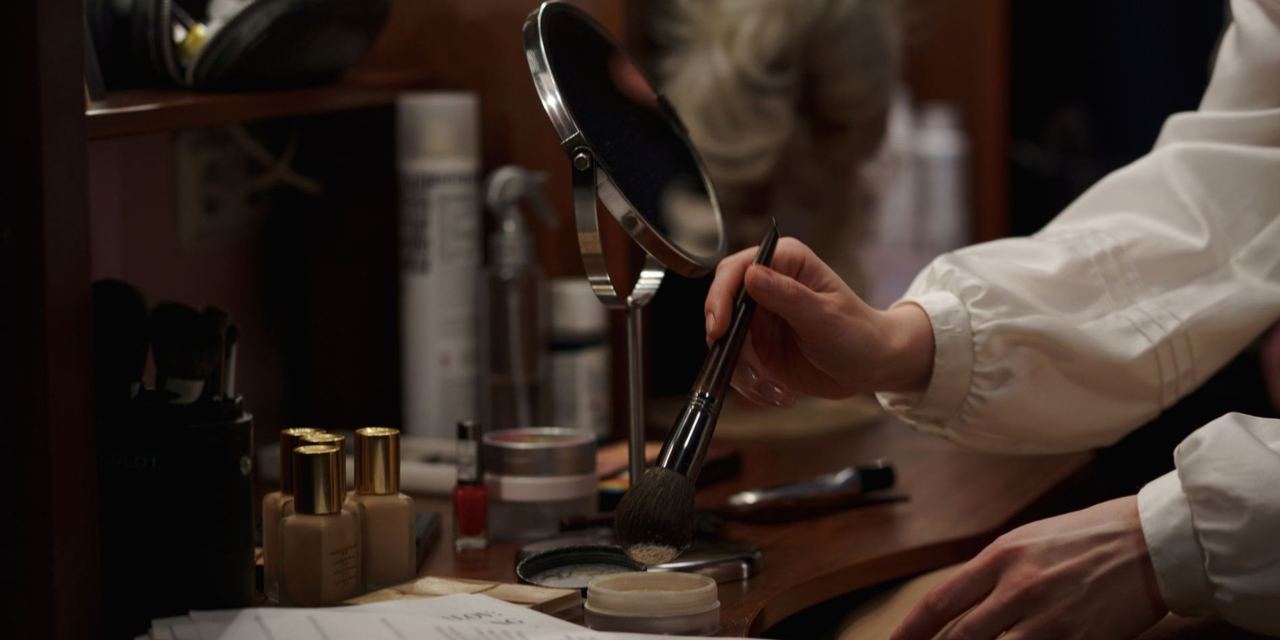 Close-up shot of a woman applying makeup in a dressing room | Source: Pexels